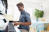 A man practices playing the piano at home.