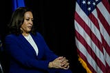 Democratic vice presidential candidate Kamala Harris sits and listen to Joe Biden’s remarks at the Alexis Dupont High School.