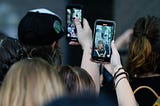 A photo of protestors recording videos on their phones.