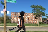 A photo of two Black youths walking down a street in Detroit.