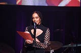 Solange accepting an award at an event.