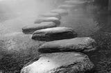Black and white stepping stones in a river.