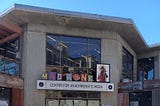 The former Cody bookstore building with its gray concrete walls and large windows in Berkeley, CA on a sunny day.