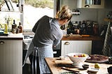 A woman cooking in her kitchen.