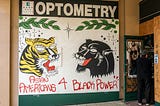 Mural: A tiger and a panther, branches, and sparkles above the text “Asian Americans 4 Black power.”
