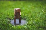 Wooden robot on a green lawn