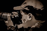 Monochrome (sepia) image of a photographer holding a camera to his eye