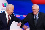 A photo of Joe Biden and Bernie Sanders elbow bumping each other at the 11th Democratic Party 2020 presidential debate.
