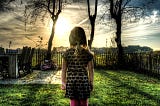 Young girl in backyard gazing into sunrise