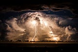 Storm clouds shroud an electrical storm of the coast of Byron Bay at night.