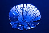 A blue-tinted photo of a shattered mirror.