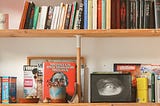 bookshelf with small fames and trinkets, Pexels