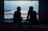 silhouette of man and woman sitting on ottoman