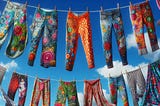 An AI-graphic of three rows of colourful pants hanging from clothes against a blue sky.