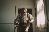 An elderly person in a vintage room wearing suspenders and a striped shirt, holding a hammer while walking. The space features wooden paneling and a lace-curtained window, evoking a historical or rustic setting.