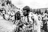 A black and white photo of the author kissing her husband on their wedding day.