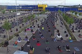 Muslim worshippers sitting at an Ikea car park