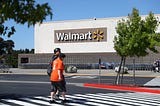 Pedestrians walk by a Walmart store.