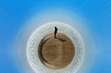 A photo of a man standing in a sphere desert.
