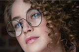 portrait of curly hair woman wearing glasses