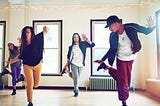 A group of young people dancing together in a studio
