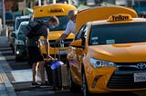 A cab driver helping a passenger load his luggage at LAX.