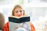 Smiling woman reading a book.