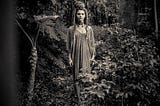 Woman in jungle with dress and braided hair.