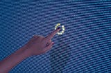A photo of a finger touching a line of code on a screen. There is a loading ring around the word that has been touched.