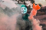 Anonymous hacker holding a war flare ready to launch a cyberattack.