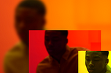 In the lower left corner of this photo is a small rectangle with closeup of a depressed-looking Black person against a yellow background. A larger, zoomed-out, slightly blurry version of the same image, but colored red, is to the left of the small rectangle, which overlaps it slightly. The background is an even more zoomed-out and blurry version of the pic, colored orange.