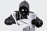 Photo of a man in a mask, gloves, and hoodie, with a ballot box in a bunch of paper in his hands — presumably attempting to steal and election.