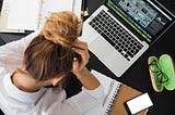 Woman distressed looking over laptop.