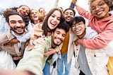 A multi-faceted group of young people smiling and enjoying each other’s company.