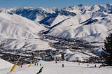 An aerial view of Sun Valley’s Bald Mountain, including snow-covered peaks, skiers, and the ski lift.