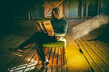An incongruous photo of a woman reading Shakespeare in an abandoned pig shed.