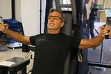 Dave Asprey at the Bulletproof Labs launch on October 11, 2017. Asprey works out his arms on a gym exercise machine.