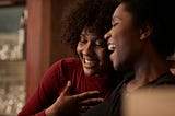 Two friends laugh together.