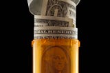 A US dollar bill rolled up in a prescription bottle.