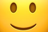 A close up of the slightly smiling emoji.
