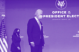 President-elect Joe Biden and Vice President-elect Kamala Harris walk on stage wearing masks.