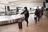 Sukhneet Dhillon, age 11, and family wear masks as they arrive from a flight from India, through Tokyo, to Sea-Tac airport.