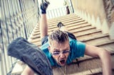 man in shorts and sunglasses falling down the stairs with a scared look in his face