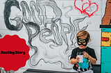 little boy with batman mask and a coffee cup in hand sits by a white brick wall that reads “Good People”