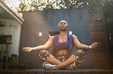 Woman meditating in the backyard.