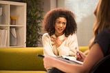 A photo of a black woman talking to a therapist.