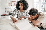 A mother helping her son study and read.