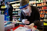 A healthcare worker takes a sample from a woman at a New York State Department of Health Covid-19 antibody testing center.