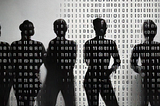 Black and white image of shadows of people in line with a pattern of ones and zeroes overlay.