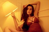 Woman in red lingerie holding a lamp